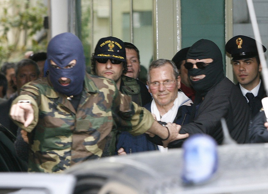 FILE - In thisTuesday, April 11, 2006 file photo, Mafia boss Bernardo Provenzano, center with white scarf, is escorted by hooded police officers as he enters a Police building in downtown Palermo, Ita ...