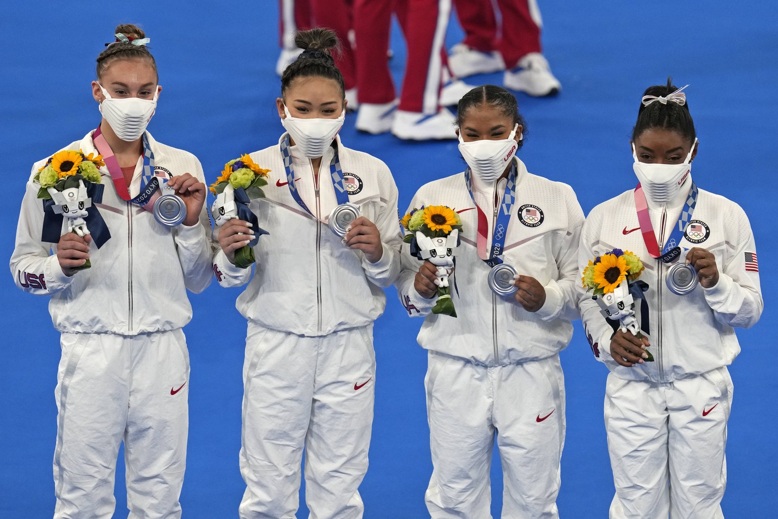 United States&#039; artistic gymnastics women&#039;s team members, from left, Grace McCallum, Sunisa Lee, Jordan Chiles and Simone Biles celebrate on the podium after winning the silver medal in the a ...