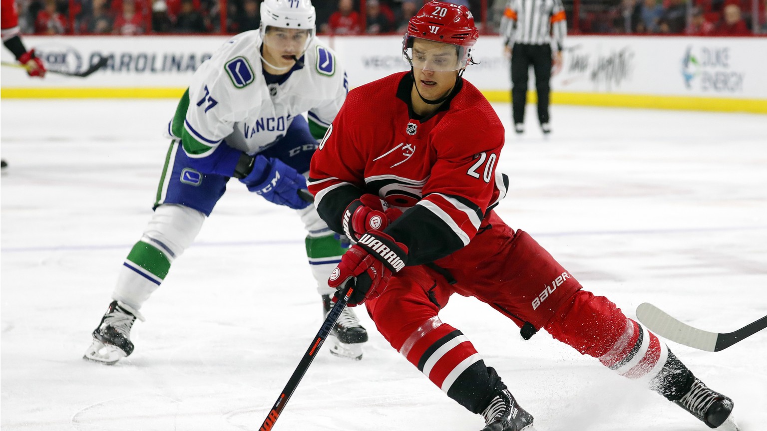 FILE - In this Oct. 9, 2018, file photo, Carolina Hurricanes&#039; Sebastian Aho (20) gathers in the puck in front of Vancouver Canucks&#039; Nikolay Goldobin (77) during the second period of an NHL h ...