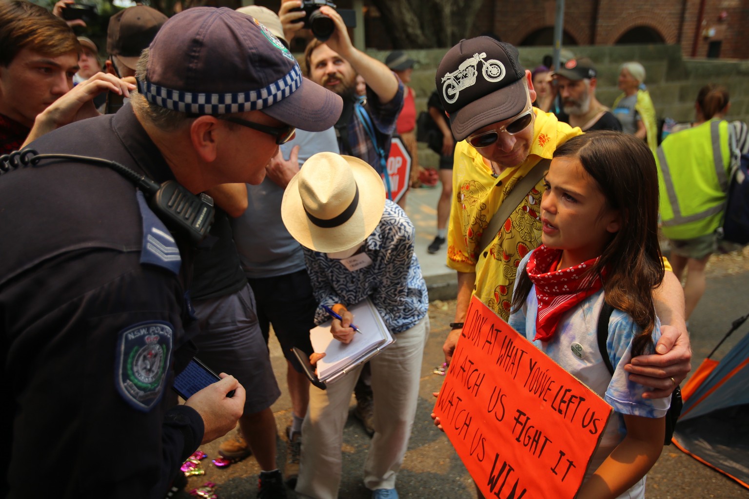 epaselect epa08080986 A policeman talks to a young girl during a protest outside Kirribilli House in Sydney, Australia, 19 December 2019. Protesters condemn Australian Prime Minister Scott Morrison&#0 ...