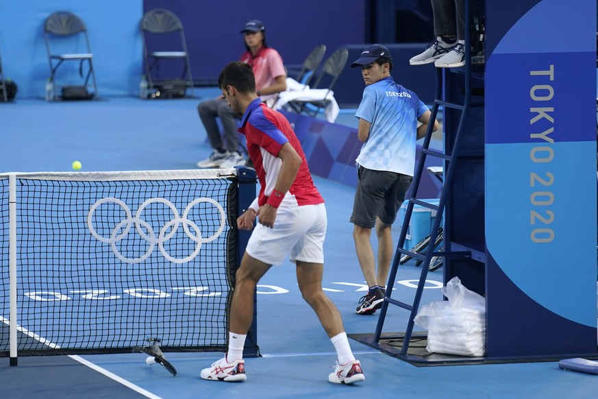 Novak Djokovic, of Serbia, breaks his racket during the bronze medal match of the tennis competition against Pablo Carreno Busta, of Spain, at the 2020 Summer Olympics, Saturday, July 31, 2021, in Tok ...