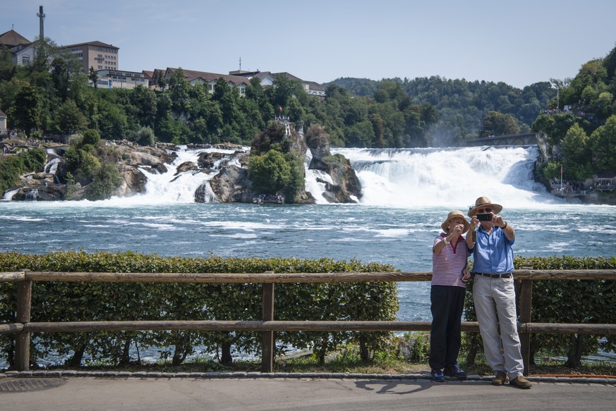 Touristen fotografieren sich vor dem Rheinfallfelsen, am Montag, 6. August 2018 in Neuhausen am Rheinfall. Der Rheinfall ist einer der drei groessten Wasserfaelle in Europa und ein beliebtes Ausflugsz ...