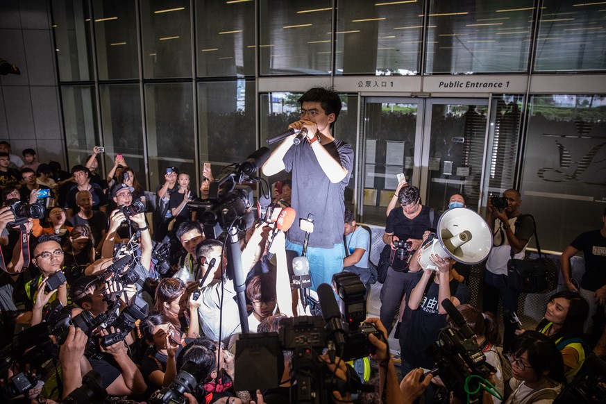 epa07653369 Demosisto Secretary General and pro-democracy activist Joshua Wong talks to the protesters after being released of prison, outside the Legislative Council building, in Hong Kong, China, 17 ...