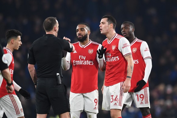 epa08148748 Arsenal players Alexandre Lacazette (C) and Granit Xhaka talk to referee Stuart Attwell during the English Premier League match between Chelsea and Arsenal in London, Britain, 21 January 2 ...