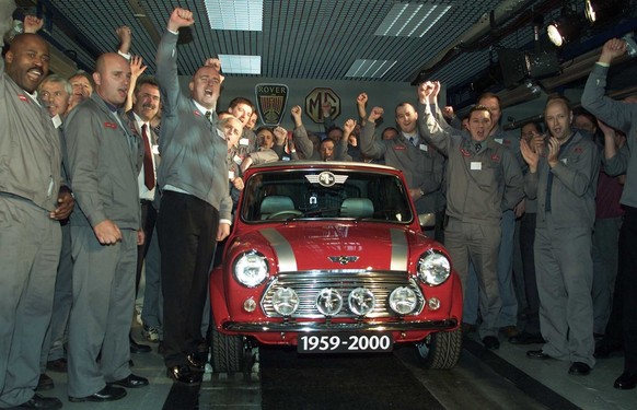 Production workers cheer as the last British Mini rolls off the production line at the Rover group&#039;s Longbridge plant in Birmingham England, Wednesday October, 4, 2000. The Mini first was produce ...