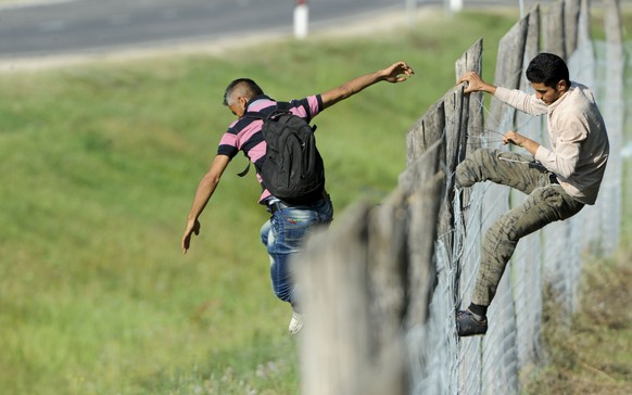 Nicht unüberwindbar: Flüchtlinge klettern bei Röszke über den Zaun.&nbsp;