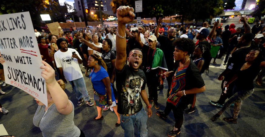 Protesters block an intersection near the Transit Center as they march uptown in Charlotte, N.C. Wednesday, Sept. 21, 2016. Authorities in Charlotte tried to quell public anger Wednesday after a polic ...