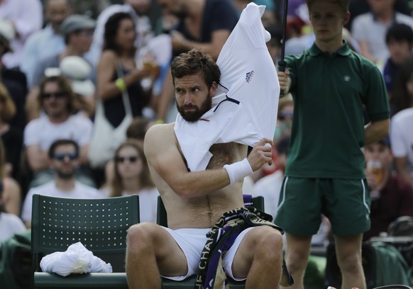 Ernests Gulbis of Latvia changes his shirt during the men&#039;s singles match against Alexander Zverev of Germany on the sixth day at the Wimbledon Tennis Championships in London, Saturday July 7, 20 ...