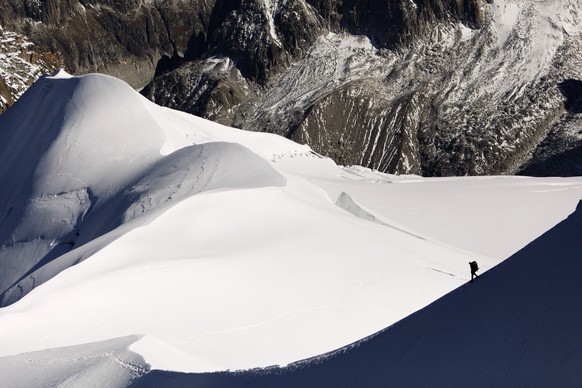 FILE - In this file photo dated Wednesday, Oct. 12, 2011, an alpinist heads down a ridge on the Aiguille du Midi (3,842 meters; 12 605 feet), towards the Vallee Blanche on the Mont Blanc massif, in th ...