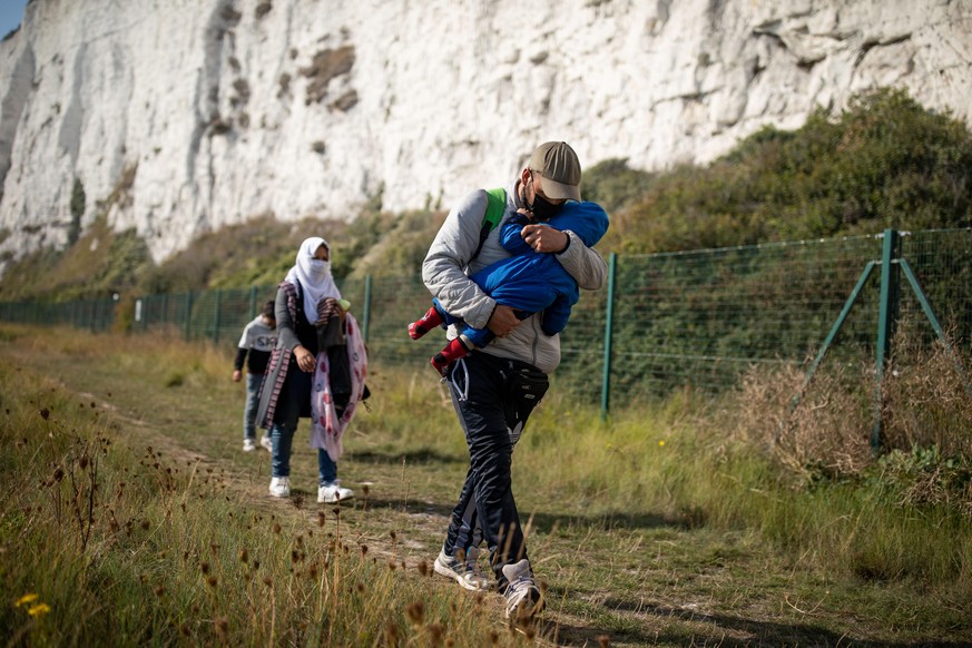 DEAL, ENGLAND - SEPTEMBER 15: A migrant family walks along the coast on September 15, 2020 at Kingsdown Beach in Deal, England. More than 6,100 migrants have made the crossing by boat this year accord ...