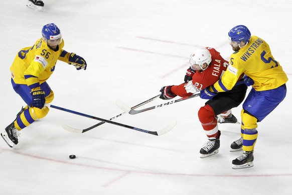 epa06734039 Switzerland&#039;s forward Kevin Fiala, center, vies for the puck with Sweden&#039;s players defender Erik Gustafsson, left, and defender Mikael Wikstrand, right, during the IIHF 2018 Worl ...