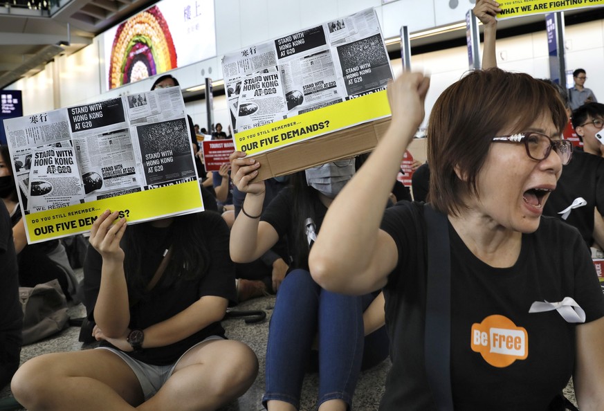 Demonstrators shout slogans during a protest at Hong Kong International Airport, Friday, July 26, 2019. Hong Kong residents have been protesting for more than a month to call for democratic reforms an ...