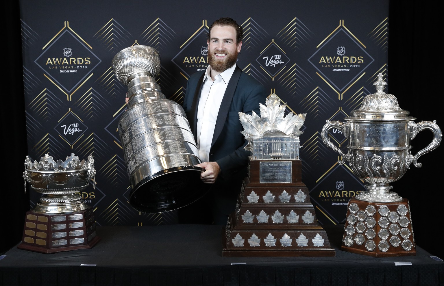 St. Louis Blues&#039; Ryan O&#039;Reilly poses with, from left, the Frank J. Selke Trophy, for top defensive forward; the Stanley Cup; the Conn Smythe Trophy, for MVP during the playoffs; and the Clar ...