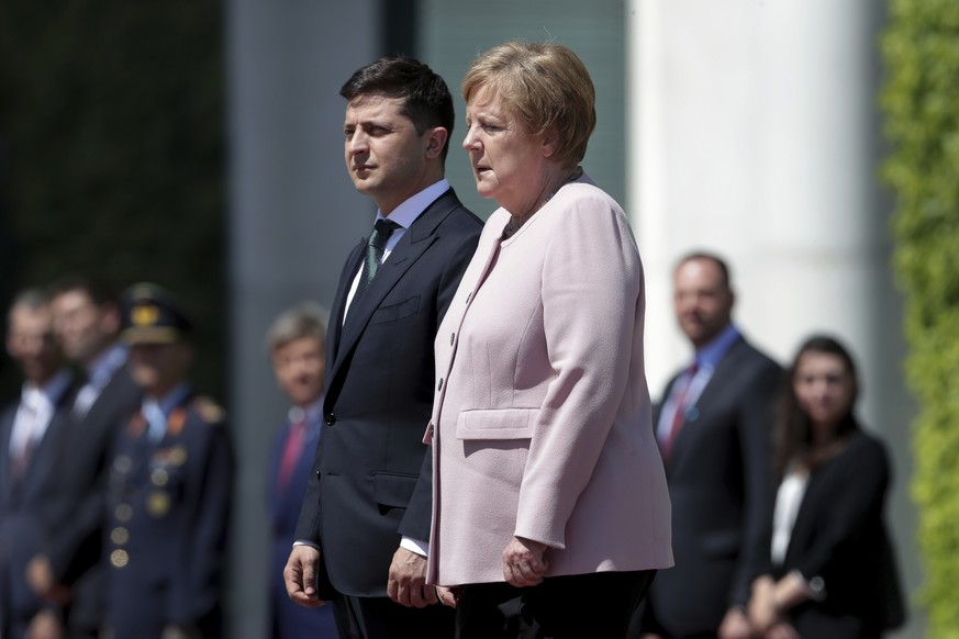 German Chancellor Angela Merkel, right, trembles strong as she and Ukraine&#039;s President Volodymyr Zelenskiy, left, attend the national anthems as part of a military welcome ceremony in Berlin, Ger ...