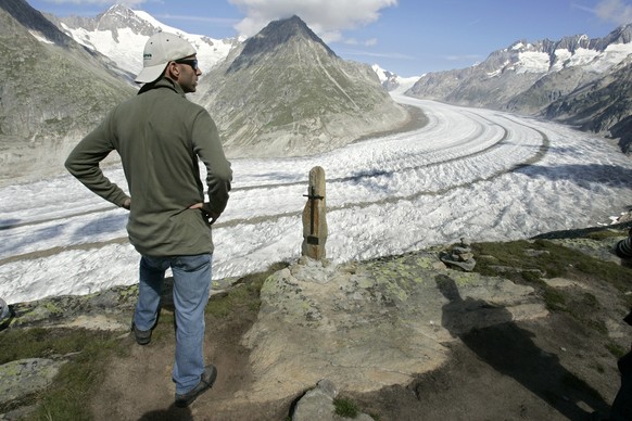 Un touriste observe le glacier d&#039; Aletsch ce samedi 18 aout 2007 pres de Bettmeralp, Valais. (KEYSTONE/Laurent Gillieron)

Ein Tourist betrachtet am 18. August 2007 den Aletschgletscher in der Na ...