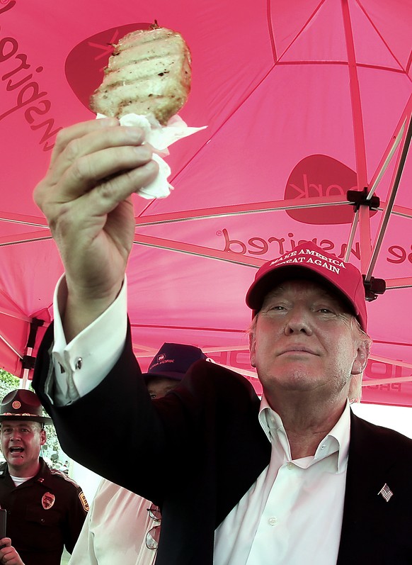 Republican presidential candidate Donald Trump eats a pork chop on a stick at the Iowa State Fair Saturday, Aug. 15, 2015, in Des Moines. (AP Photo/Charlie Riedel)