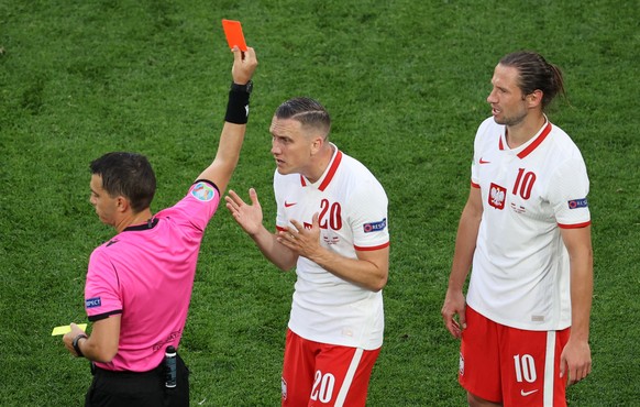 epa09271174 Romanian referee Ovidin Hategan (L) shows the red card to Grzegorz Krychowiak (R) of Poland during the UEFA EURO 2020 group E preliminary round soccer match between Poland and Slovakia in  ...