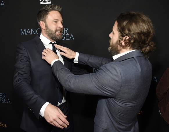 Casey Affleck, right, a cast member in &quot;Manchester by the Sea,&quot; fixes the tie of his brother Ben Affleck at the premiere of the film at the Samuel Goldwyn Theater on Monday, Nov. 14, 2016, i ...