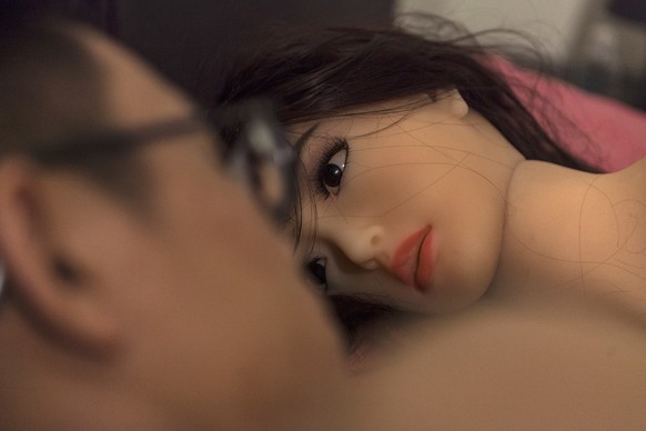 epa06758674 (17/24) Chen interacts with his &#039;smart&#039; sex doll as he lays in a bed in his home in Guangzhou, Guandong Province, China, 05 April 2018. Chen, because of his busy pharmaceutical s ...