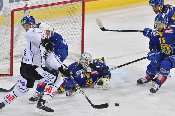 Luganos Jani Lajunen, links prueft die Davoser Marc Aeschlimann und Torhueter Sandro Aeschlimann, beim Eishockey-Qualifikationsspiel der National League A zwischen dem HC Davos und dem HC Lugano, am S ...