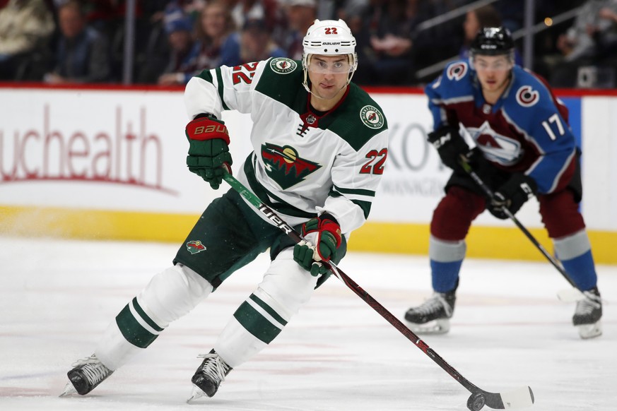 Minnesota Wild right wing Nino Niederreiter, front, picks up the puck as Colorado Avalanche center Tyson Jost drops back to defend in the first period of an NHL hockey game Friday, March 2, 2018, in D ...