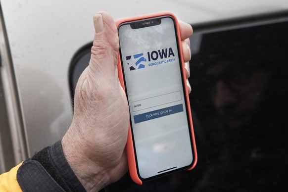 Precinct captain Carl Voss of Des Moines displays the Iowa Democratic Party caucus reporting app on his phone outside of the Iowa Democratic Party headquarters in Des Moines, Iowa, Tuesday, Feb. 4, 20 ...