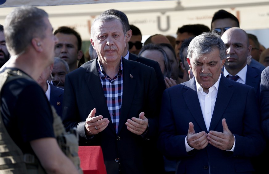 epa05429408 Turkish President Recep Tayyip Erdogan (L) and former president Abdullah Gul (R) pray near by coffins of Erol Olcok and his son Abdullah Tayyip Olcok, who were killed in a coup attempt on  ...