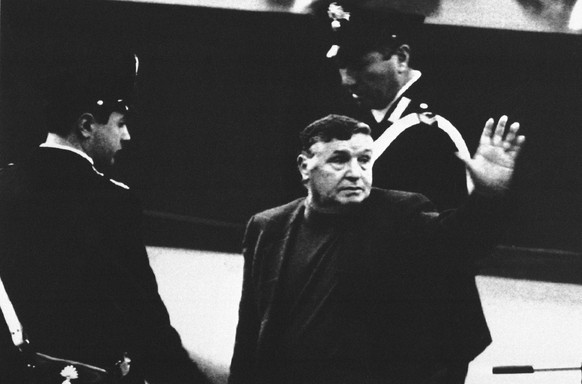 FILE - In this March 4, 1993 file photo, Mafia boss Salvatore Riina waves to family and supporters as he is taken away by police following a court appearance in Palermo, southern Italy. Italian media  ...