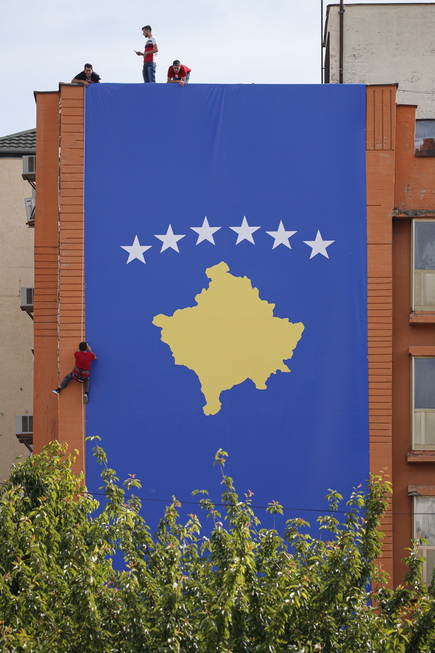 epa07641160 Workers place a giant flag of Kosovo in the center of Pristina, Kosovo, 11 June 2019. On 12 June 2019 Kosovo will celebrate the 20th anniversary of the ending of the war and the entrance o ...