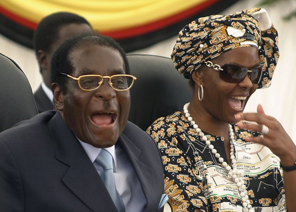 FILE - In this March 27, 2008 file photo Zimbabwean President Robert Mugabe, left, and his wife Grace, right, react during a visit to Harare hospital in Harare, Zimbabwe, Mugabe seemed almost untoucha ...