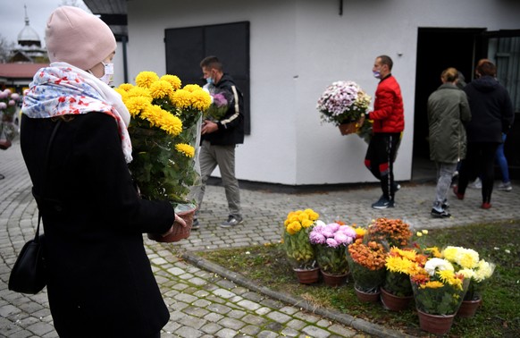 epa08804224 Volunteers distribute chrysanthemums to help vendors who were unable to sell their flowers on All Saints&#039; Day due to the COVID-19 restrictions, in Fredropol, Poland, 07 November 2020. ...