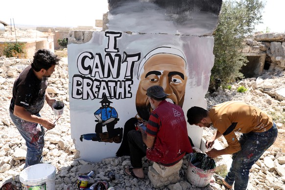 epa08458370 Syrians spray graffiti to honor the killed US man George Floyd on the wall of a house destroyed by war, Idlib, Syria, 01 June 2020. A bystander&#039;s video posted online on 25 May appeare ...