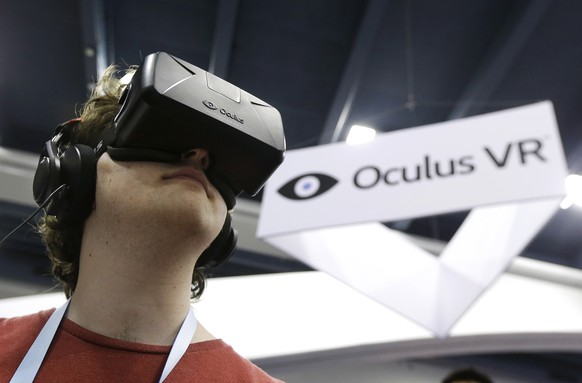 FILE - In this March 19, 2014 file photo, Peter Mason tries the Oculus virtual reality headset at the Game Developers Conference 2014 in San Francisco. Oculus, the virtual reality company acquired by  ...
