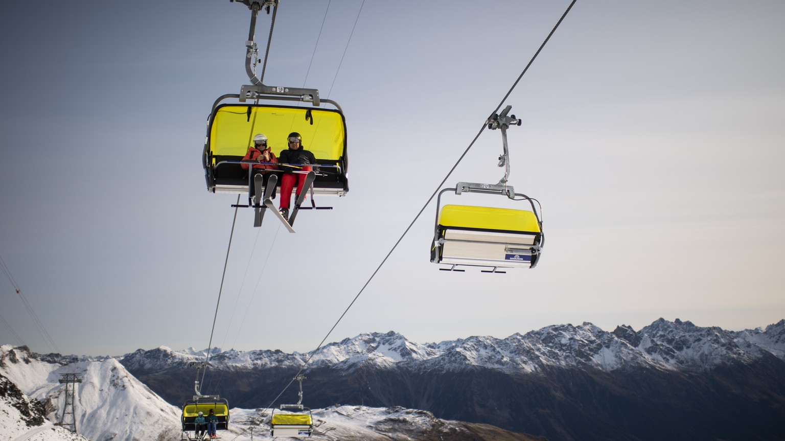 Menschen auf einem Sessellift, aufgenommen zum Start der Skisaison, am Sonntag, 25. Oktober 2020, auf Parsenn in Davos. Das Skigebiet Davos Klosters startet den Wochenendbetrieb. (KEYSTONE/Gian Ehrenz ...