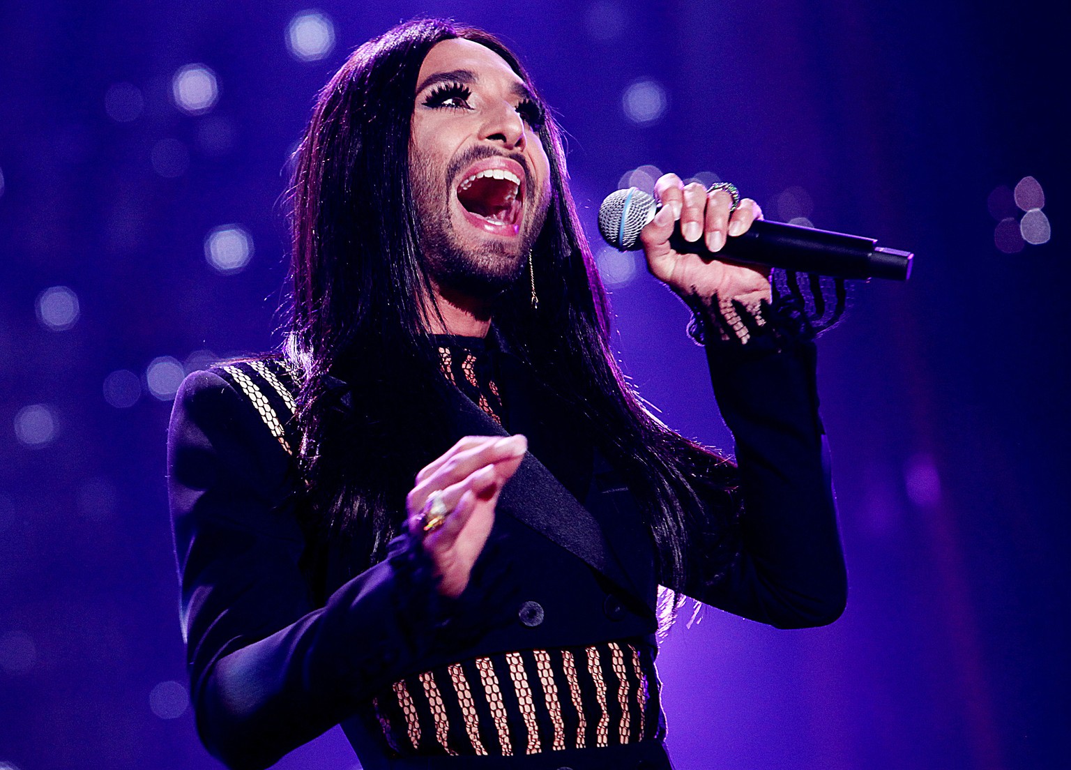Austrian cross-dressing diva Conchita Wurst sings at a concert in Kielce, Poland, on Saturday, June 27, 2015. Local authorities banned music fans from bringing glass bottles and metal objects to the c ...