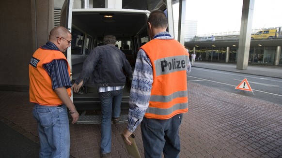 Polizisten bringen im Kanton Bern einen straffällig gewordenen Ausländer zum Airport.