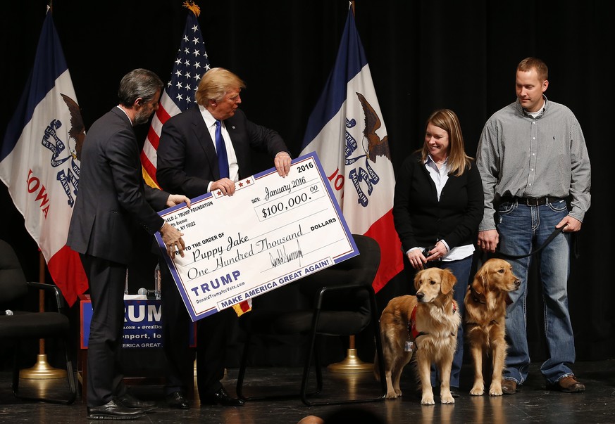 FILE - In this Jan. 30, 2016 file photo, Donald Trump, second from left, stages a check presentation with an enlarged copy of a $100,000 contribution from the Donald J. Trump Foundation to Puppy Jake, ...