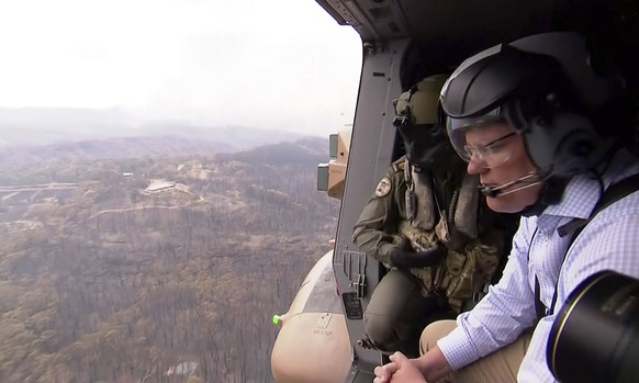In this image made from video, Australia&#039;s Prime Minister Scott Morrison looks at fire damage from helicopter near Gospers Mountain, New South Wales Monday, Dec. 23, 2019. Around 200 wildfires we ...