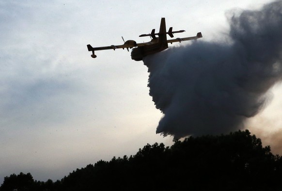 A Canadair plane drops water on a forest fire in Anglet, southwestern France, Thursday July 30, 2020. At 23 hours more than 50 hectares of forest burned. (AP Photo/Bob Edme)