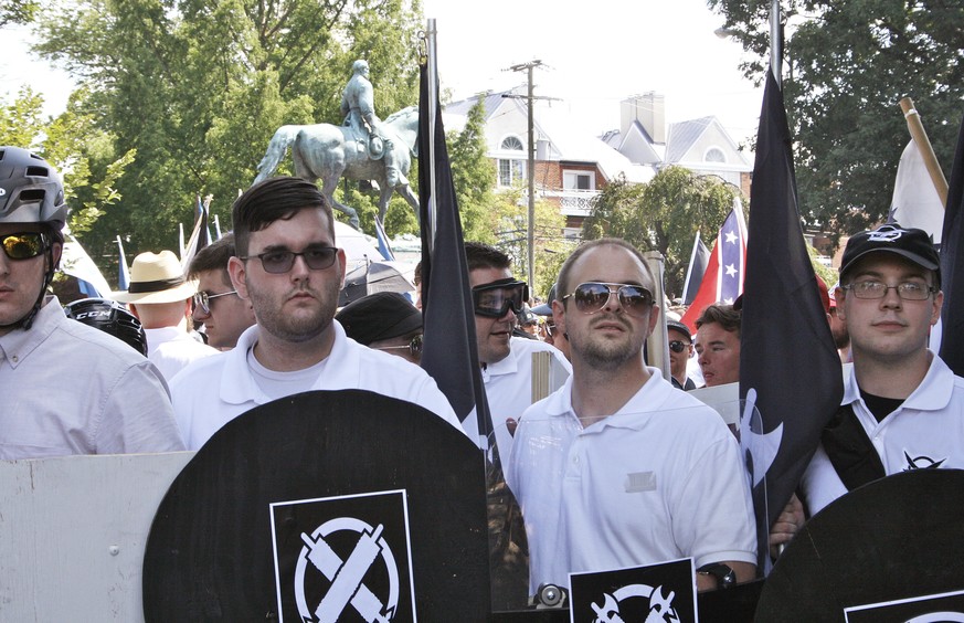 In this Saturday, Aug. 12, 2017 photo, James Alex Fields Jr., second from left, holds a black shield in Charlottesville, Va., where a white supremacist rally took place. Fields was later charged with  ...