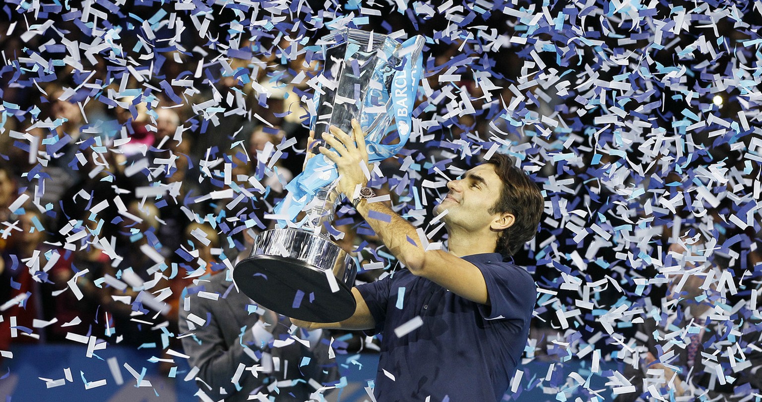 Roger Federer of Switzerland holds up the winners trophy after he defeated Jo-Wilfried Tsonga of France in thier singles final tennis match at the ATP World Tour Finals, in the O2 arena in London, Sun ...