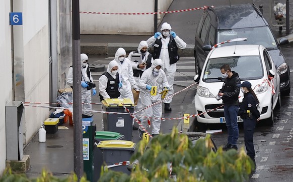 epa08697372 French forensic police investigators work at the site of the knife attack near the former Charlie Hebdo offices, in Paris, France, 25 September 2020, after two people have been wounded. Ac ...