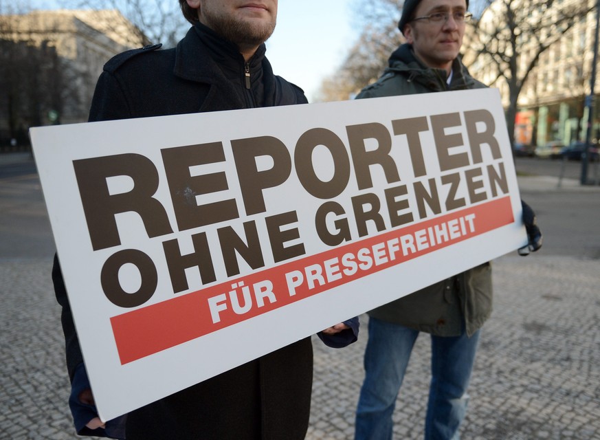 epa04054303 Protesters of the organization &#039;Reporter ohne Grenzen&#039; (lit. Reporters Without Borders, or RWB) hold a placard &#039;for freedom of press&#039; as they stand in front of the Russ ...
