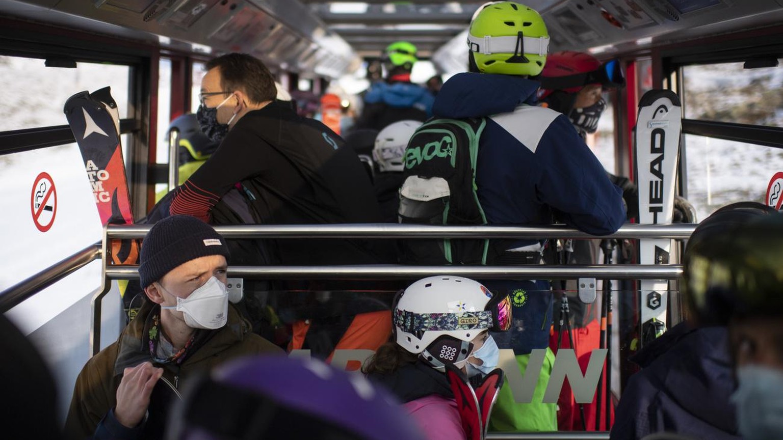 Menschen mit Schutzmasken in der Parsenn-Bahn, aufgenommen zum Start der Skisaison, am Sonntag, 25. Oktober 2020, in Davos. Das Skigebiet Davos Klosters startet den Wochenendbetrieb. (KEYSTONE/Gian Eh ...