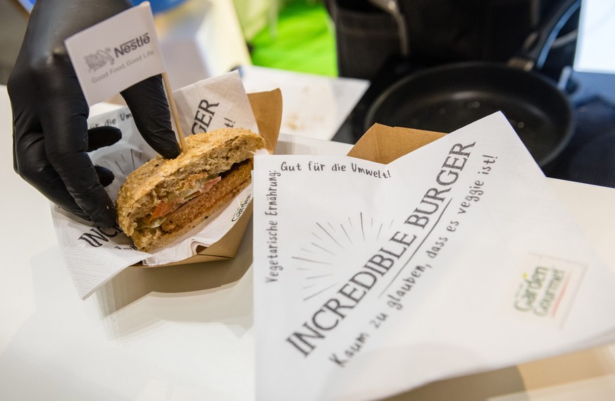epa07296533 An employee presents the &#039;Incredible Burger&#039; - a vegetarian burger by Nestle - at the International Green Week fair in Berlin, Germany, 18 January 2019. The International Green W ...