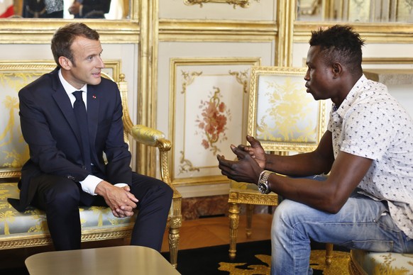 epa06768221 French President Emmanuel Macron (L) meets with Mamoudou Gassama from Mali, at the presidential Elysee Palace in Paris, France, 28 May 2018. The 22 year old migrant Mamoudou Gassama, who i ...