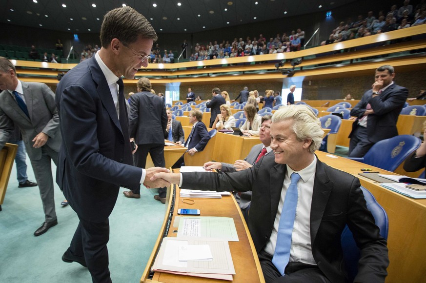 epa04889037 Handshake and smile exchange between Dutch Prime Minister Mark Rutte (left) and right wing Dutch Party for Freedom leader Geeert Wilders before the debate in the Dutch Parliament 19 August ...