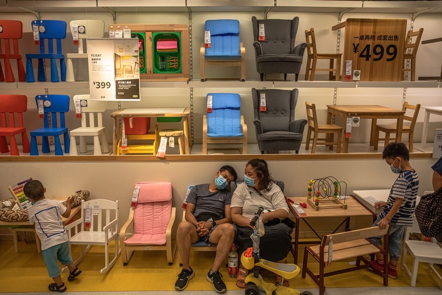 epaselect epa08539965 Shoppers wearing protective face masks rest as they visit an IKEA store in Beijing, China, 11 July 2020. China races to contain a second wave of coronavi?rus disease (COVID-19) c ...