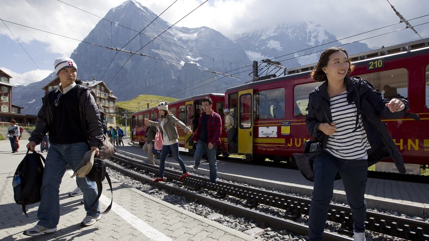 ZUR BILANZMEDIENKONFERENZ DER JUNGFRAUBAHN, AM MITTWOCH, DEM 22. APRIL 2015, STELLEN WIR IHNEN FOLGENDES ARCHIVBILD ZUR VERFUEGUNG - Touristen steigen aus einem Zug der Jungfraubahn unterhalb des Eige ...