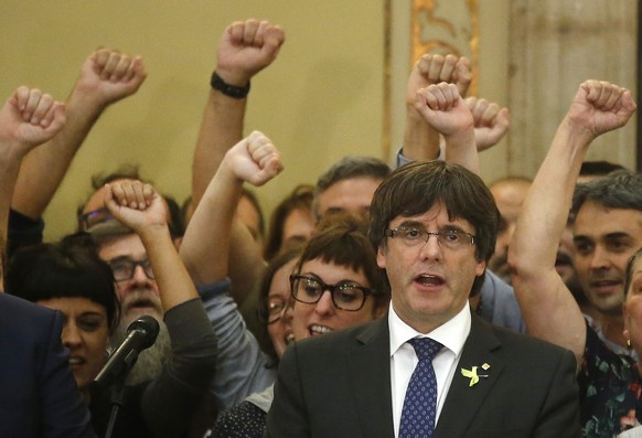 FILE- In this Friday, Oct. 27, 2017 file photo, Catalan President Carles Puigdemont sings the Catalan anthem inside the parliament after a vote on independence in Barcelona, Spain. Pro-independence Ca ...